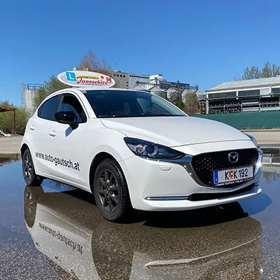 Weißer Mazda 2 mit Dachschild
